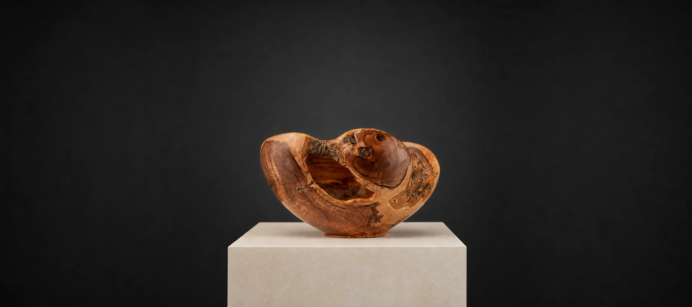 Small Natural-Edge Wild Olive, a one-of-one Wild Olive sculpture by Rodney Band, centred on a warm limestone plinth against a charcoal studio ground.