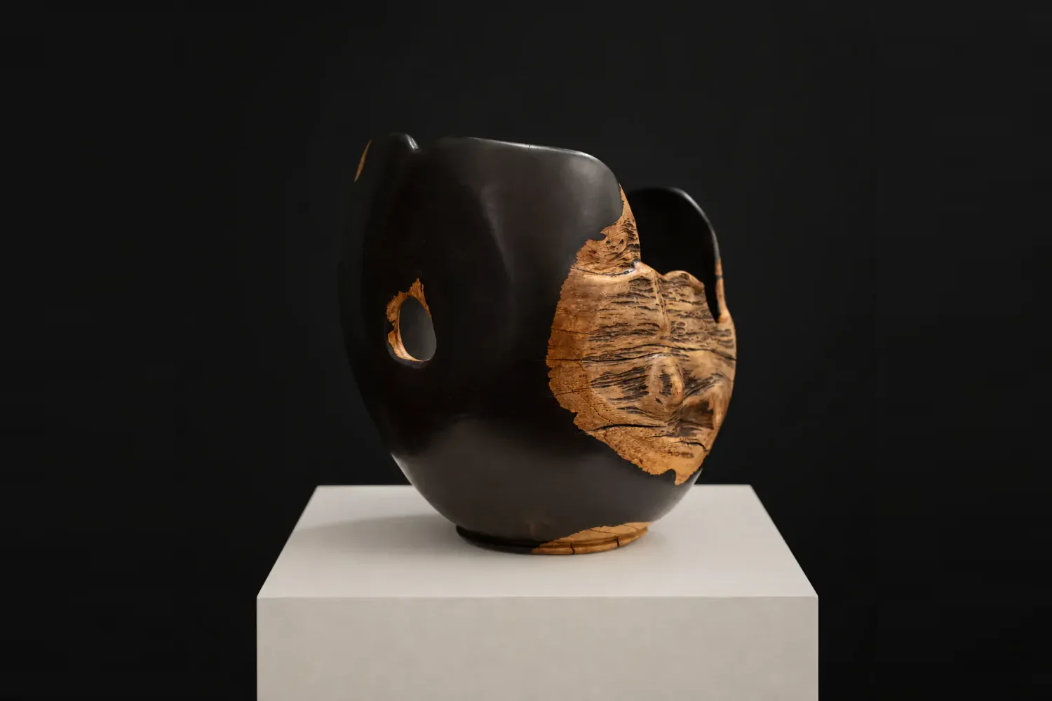 Large Natural-Edged African Blackwood Bowl, a one-of-one African Blackwood sculpture by Rodney Band, centred on a warm limestone plinth against a charcoal studio ground.