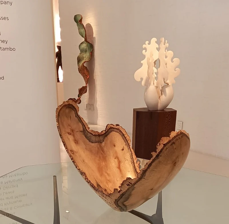 A finished natural-edge wooden bowl displayed in a gallery.